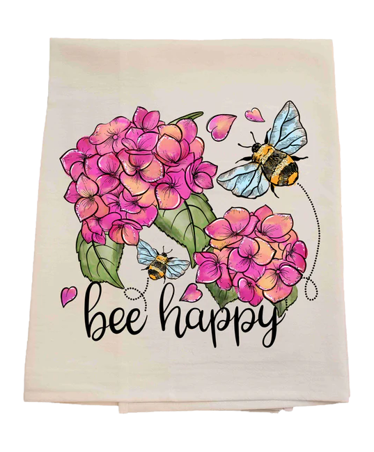 Floral towel with pink flowers, bees, and 'bee happy' text on a white background