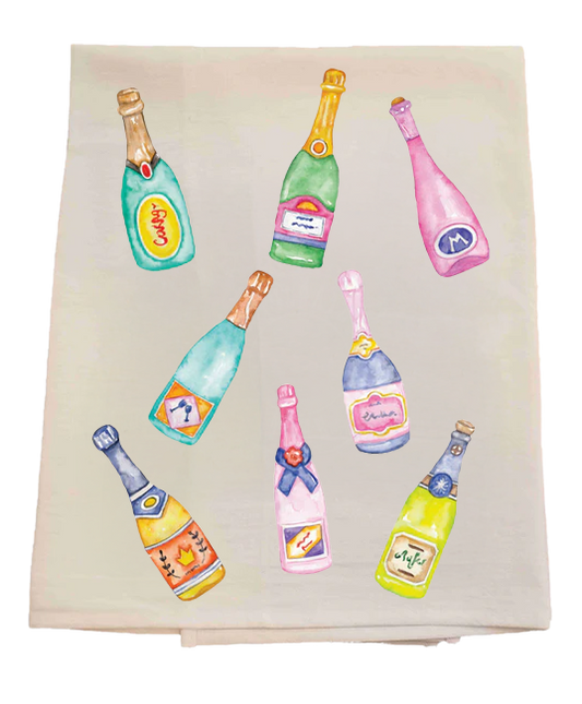 Tea towel with colorful champagne bottle illustrations on a white background
