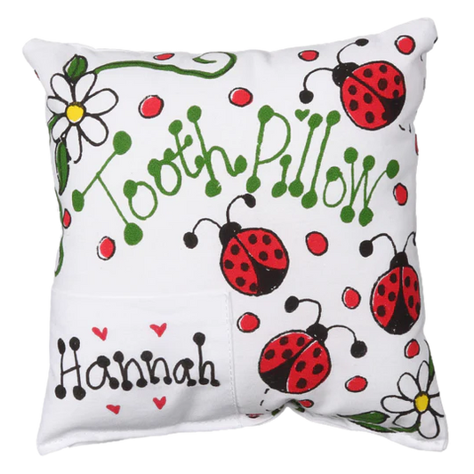 Tooth pillow with ladybug and flower patterns on a white background