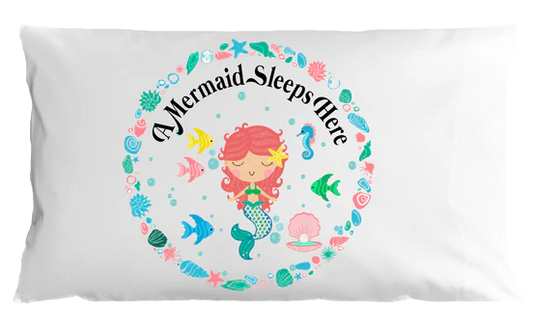 Pillow case with mermaid design and 'A Mermaid Sleeps Here' text on a white background