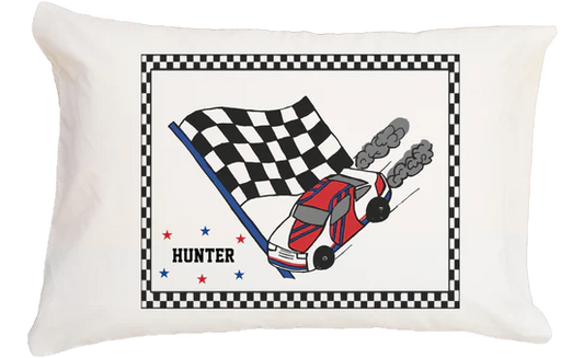 Pillow with race car and checkered flag design on a white background