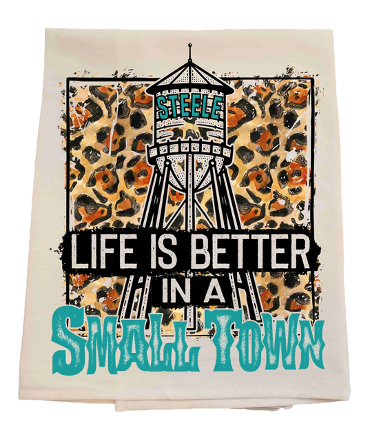Towel with water tower graphic and text 'Life is better in a small town' on a white background