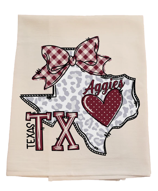 Decorative towel with Texas-themed design featuring a bow, heart, and 'Aggies' text on a white background.