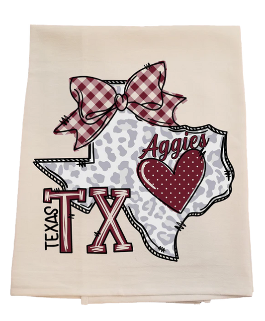 Decorative towel with Texas-themed design featuring a bow, heart, and 'Aggies' text on a white background.