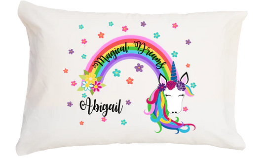Pillow with unicorn design, rainbow, and 'Magical Dreams Abigail' text on a white background